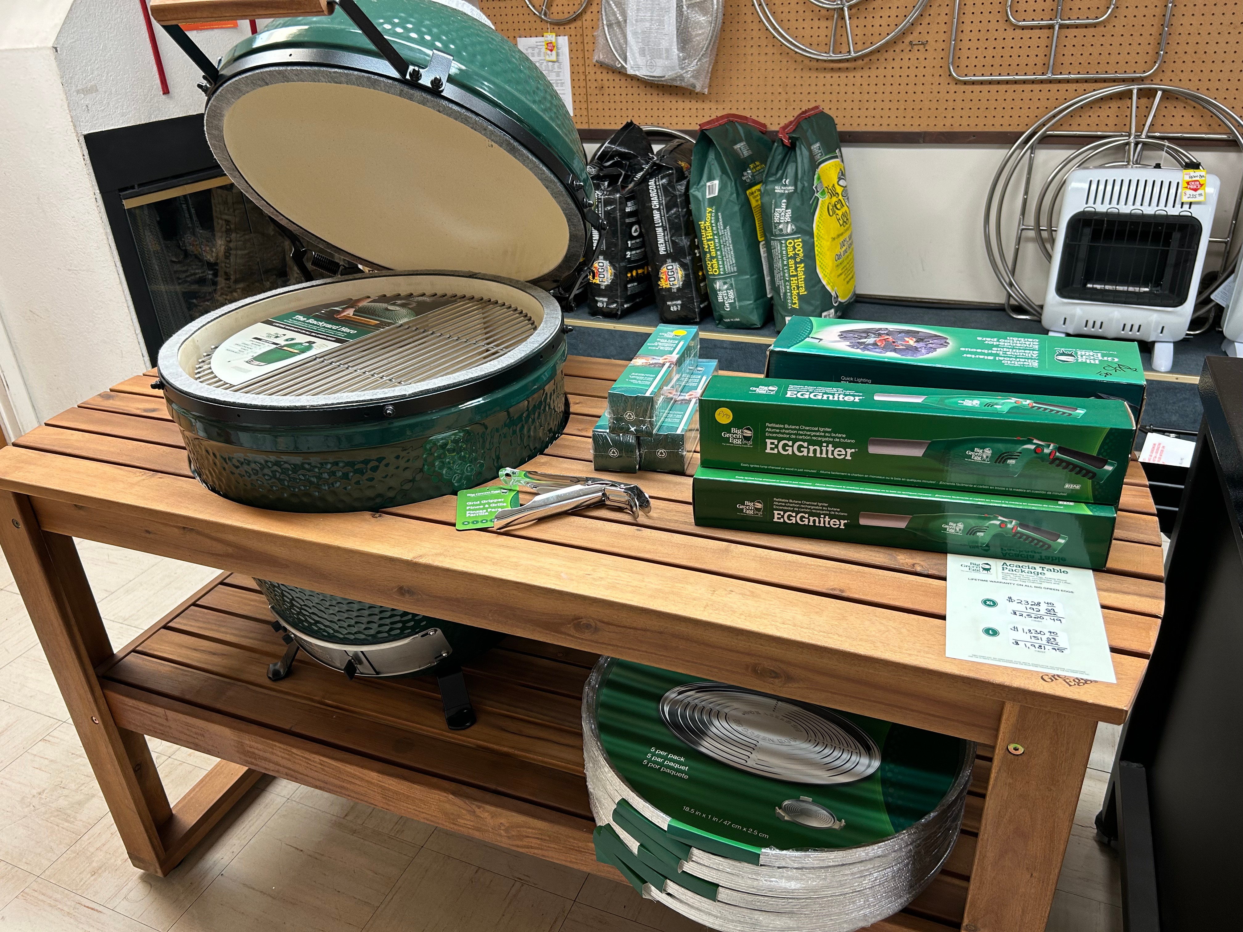 Big Green Egg on display table with EGGniter accessories and charcoal at Action Propane